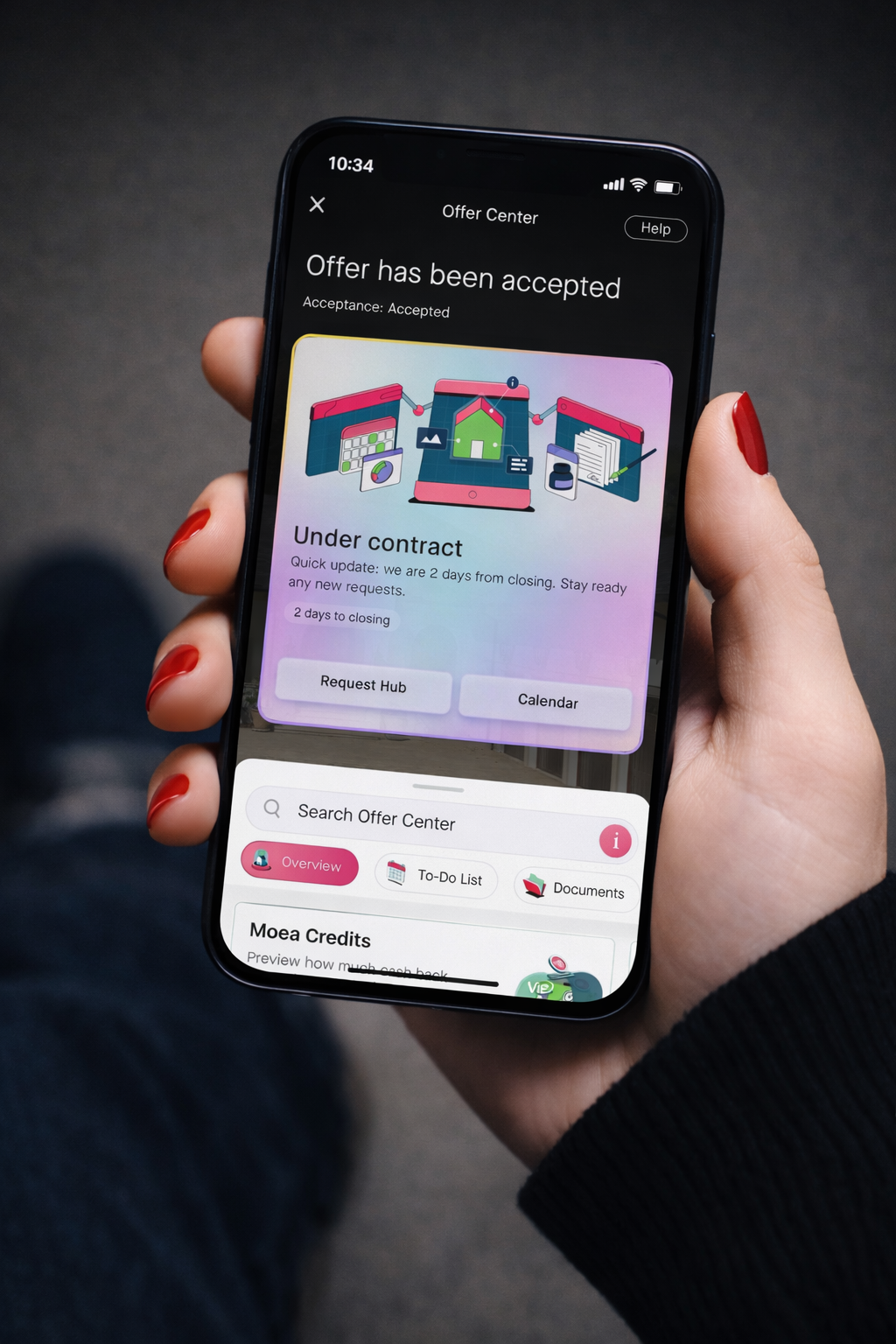 Hand holding a phone showing Moea offer progress, savings, and closing flow